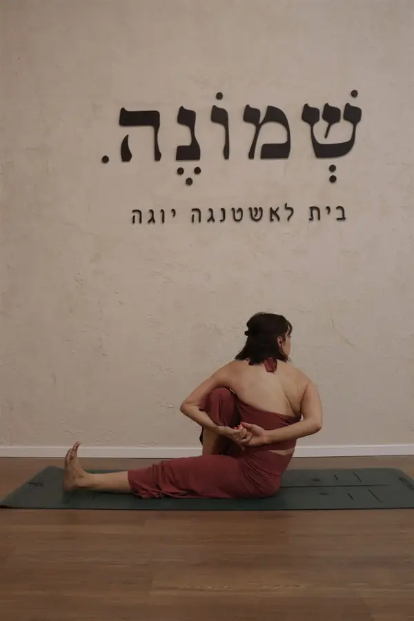 תנוחת פיתול בישיבה מתחת ללוגו הסטודיו